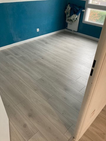 Remplacement de la moquette / du lino par du parquet stratifié aspect chêne gris.